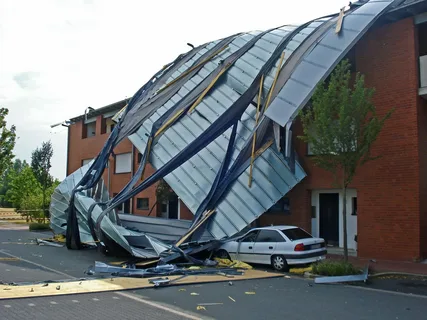 Contractors repairing siding and roof after major storm damage