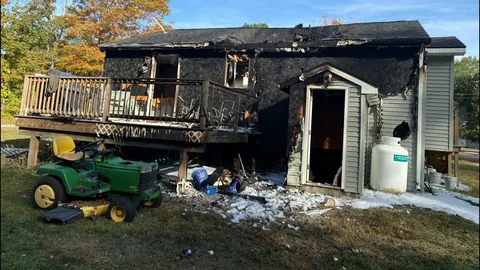 Firefighter inspecting heavily burned interior structure after residential fire before fire damage restoration in Edmond
